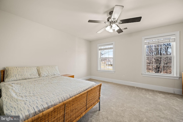 carpeted bedroom with visible vents, baseboards, and a ceiling fan