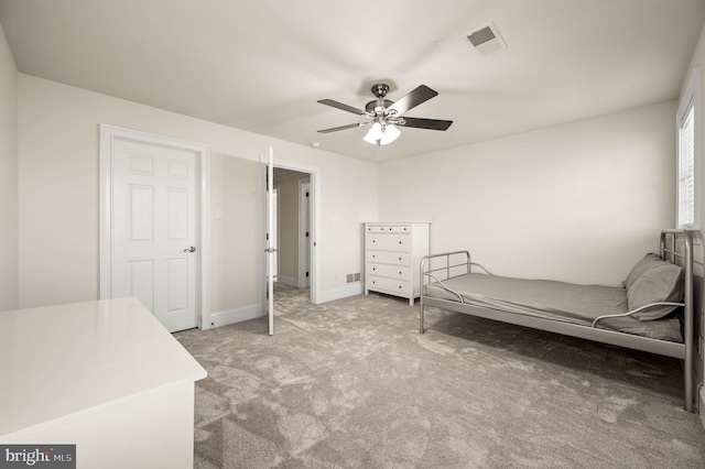 bedroom featuring visible vents, light colored carpet, baseboards, and a ceiling fan