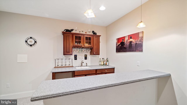 bar with baseboards, pendant lighting, carpet floors, wet bar, and a sink