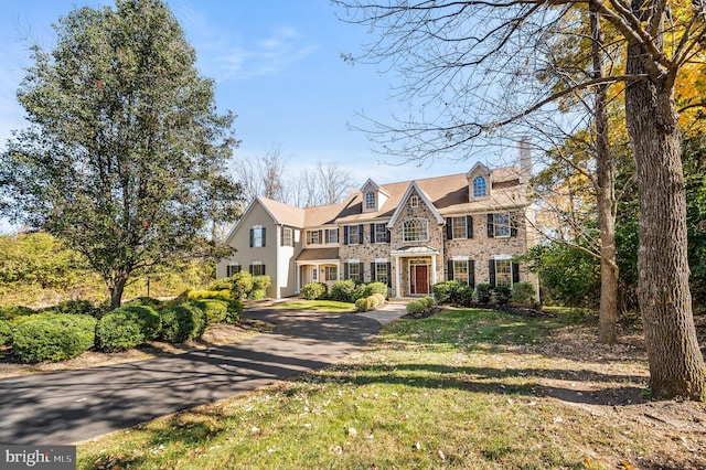 view of front facade with stone siding and a front yard