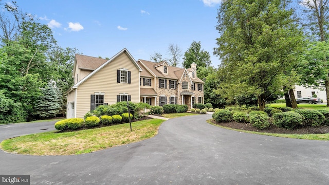 view of front of property with aphalt driveway and a chimney