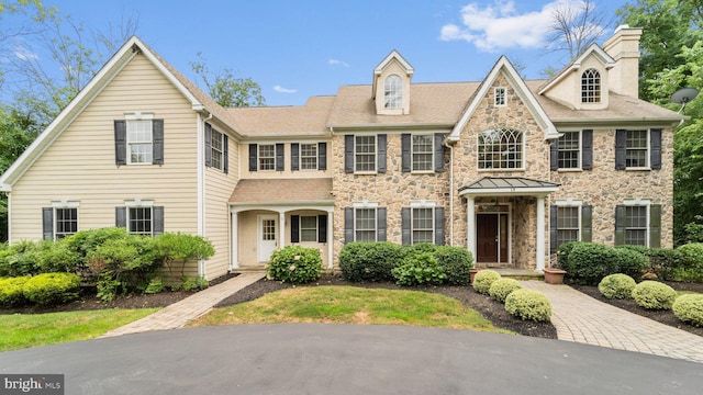 view of front of home featuring stone siding and a chimney