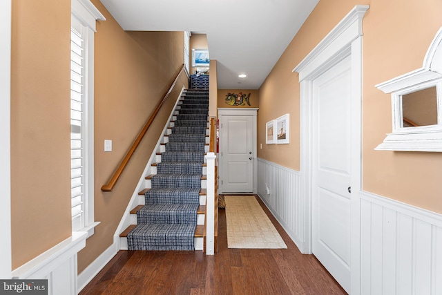 stairway featuring a wainscoted wall and wood finished floors