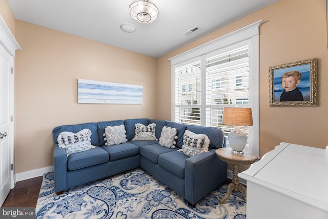 living room with visible vents, baseboards, and wood finished floors