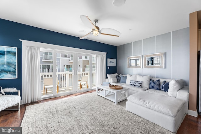 living room with dark wood-type flooring and ceiling fan