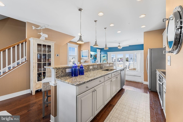 kitchen featuring a sink, appliances with stainless steel finishes, white cabinets, a ceiling fan, and dark wood-style flooring