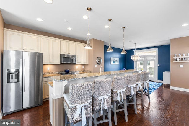 kitchen featuring dark wood finished floors, recessed lighting, light stone countertops, and stainless steel appliances