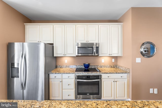 kitchen with appliances with stainless steel finishes, white cabinetry, and light stone countertops