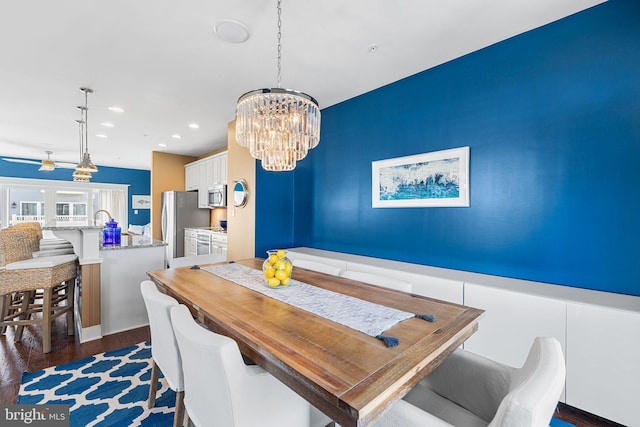 dining space featuring dark wood finished floors, recessed lighting, and an inviting chandelier