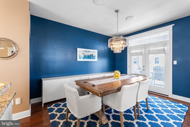 dining area featuring baseboards, an inviting chandelier, and wood finished floors