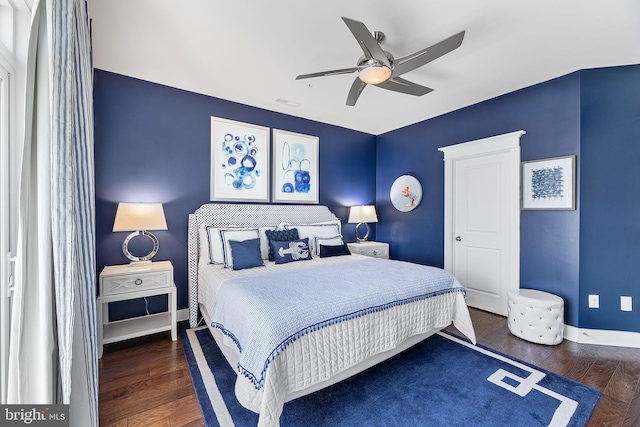 bedroom featuring ceiling fan, visible vents, baseboards, and wood finished floors