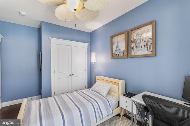 bedroom featuring a closet, baseboards, a ceiling fan, and wood finished floors