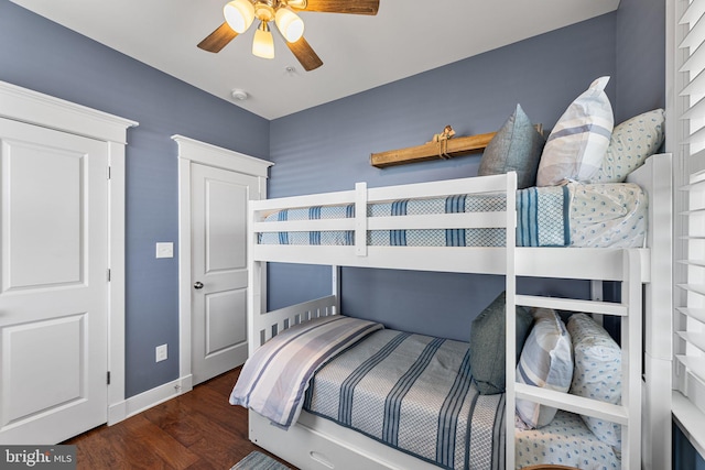 bedroom featuring baseboards, wood finished floors, and a ceiling fan