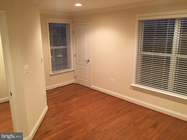 unfurnished bedroom with baseboards, wood finished floors, and ornamental molding