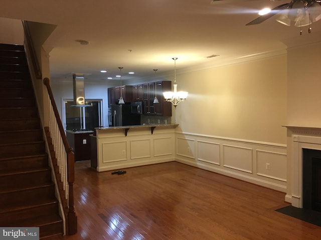 kitchen with ornamental molding, island exhaust hood, fridge, a peninsula, and dark wood-style flooring