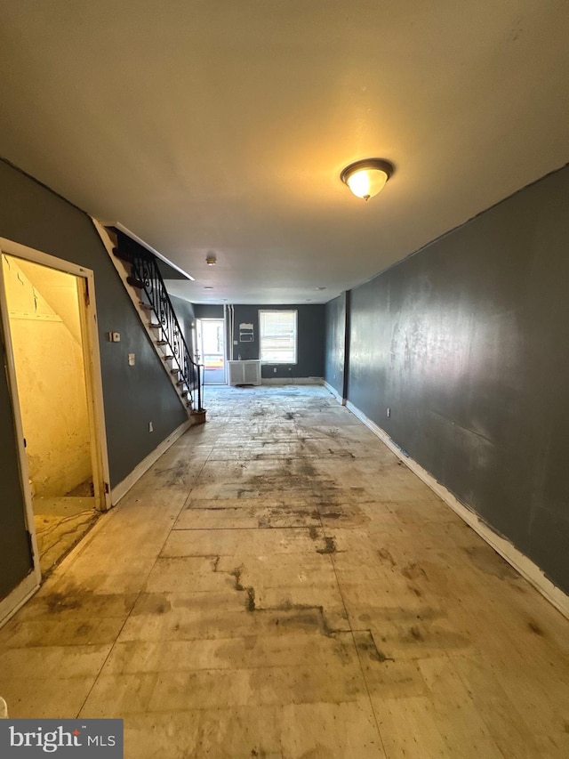 hall featuring stairway and baseboards