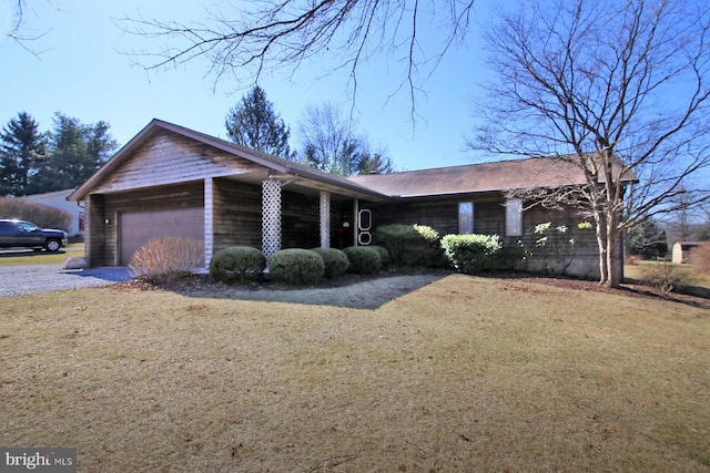 single story home with an attached garage, gravel driveway, and a front lawn