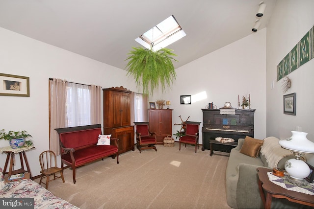 living area with a skylight, high vaulted ceiling, and light carpet