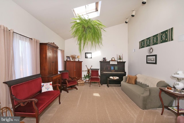 sitting room featuring carpet floors, high vaulted ceiling, and a skylight