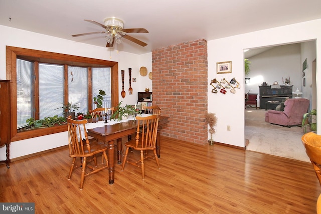 dining room featuring baseboards, a ceiling fan, and light wood finished floors