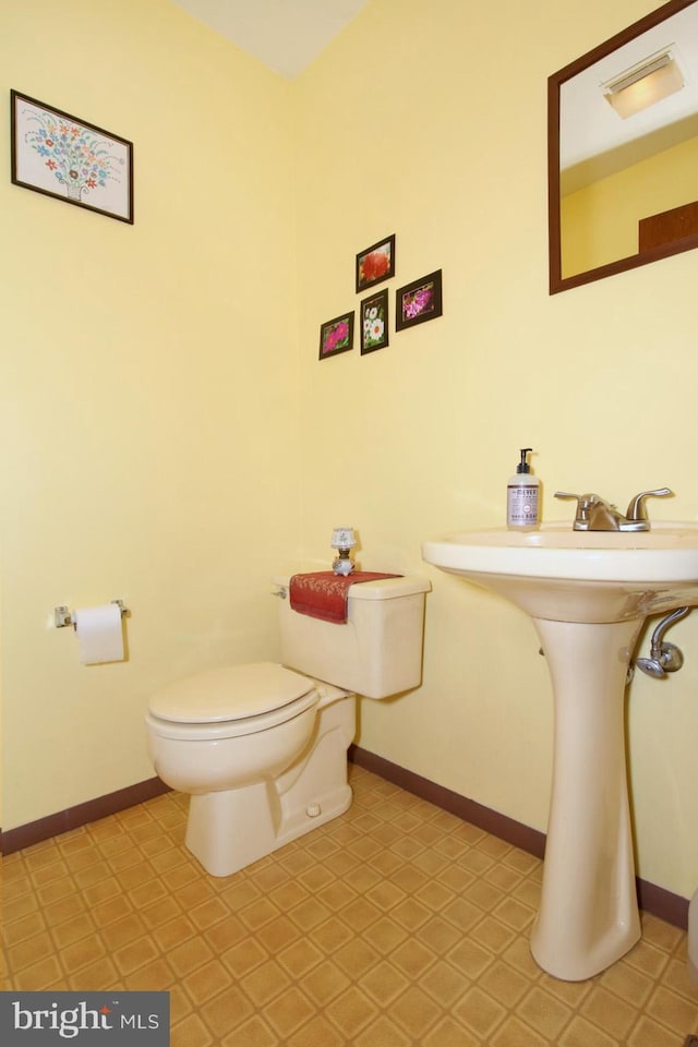 bathroom with toilet and baseboards