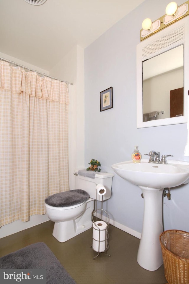 bathroom with toilet and baseboards