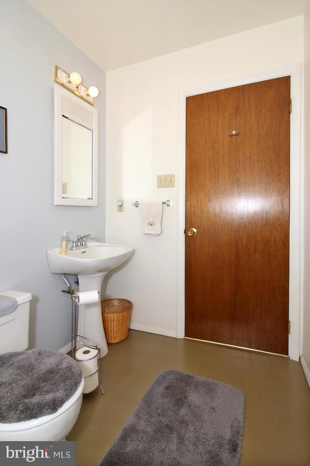 bathroom with baseboards and toilet