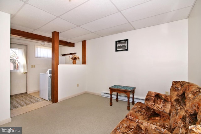 living area with baseboards, a drop ceiling, baseboard heating, washer / dryer, and carpet flooring