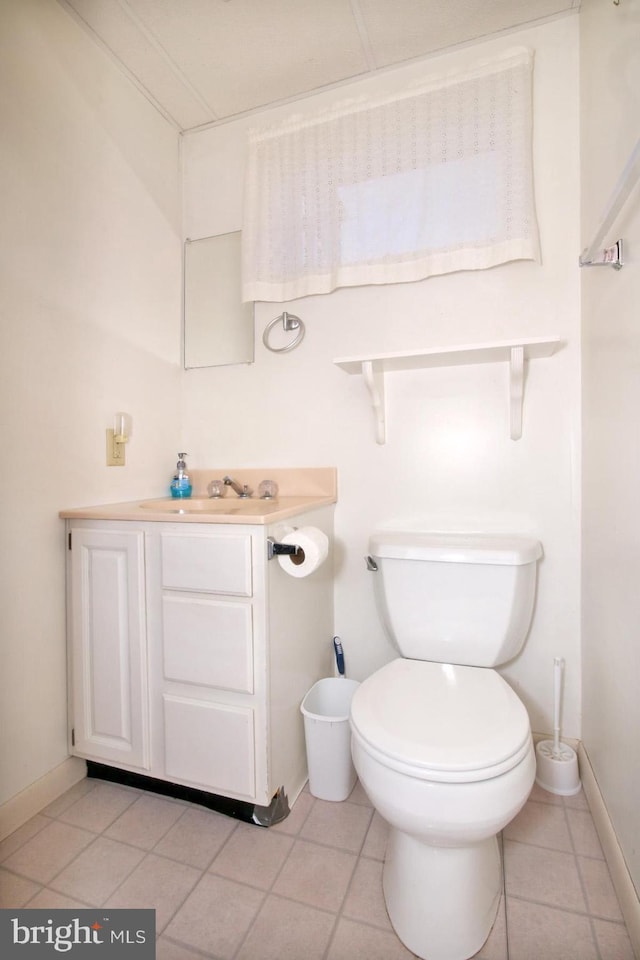 bathroom featuring tile patterned floors, baseboards, toilet, and vanity