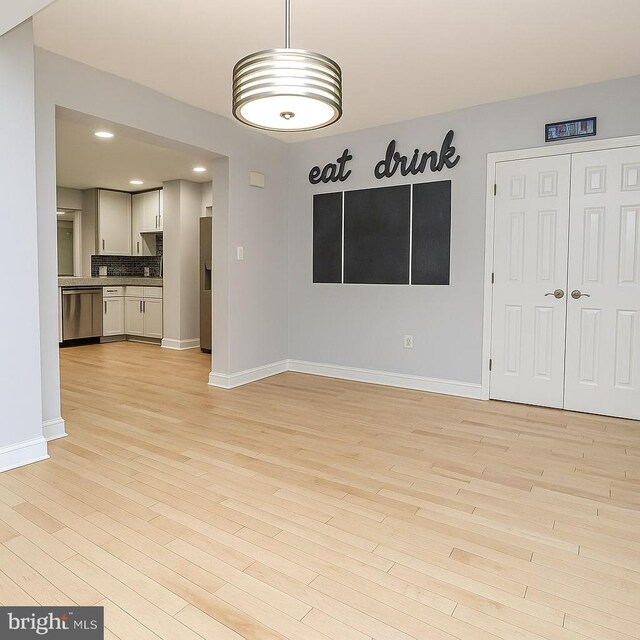 unfurnished living room with recessed lighting, baseboards, and light wood-style flooring