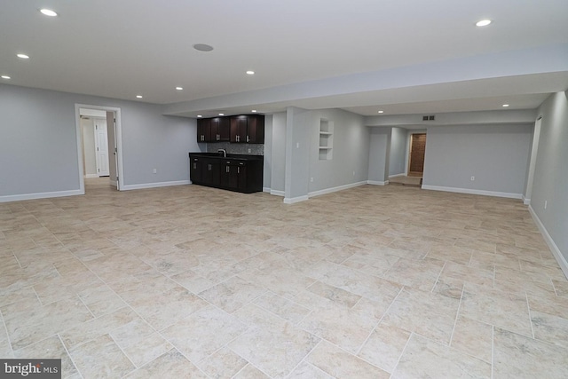 finished below grade area featuring recessed lighting, wet bar, and baseboards