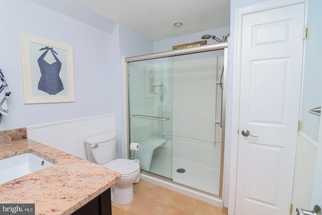 bathroom featuring vanity, tile patterned floors, a stall shower, and toilet