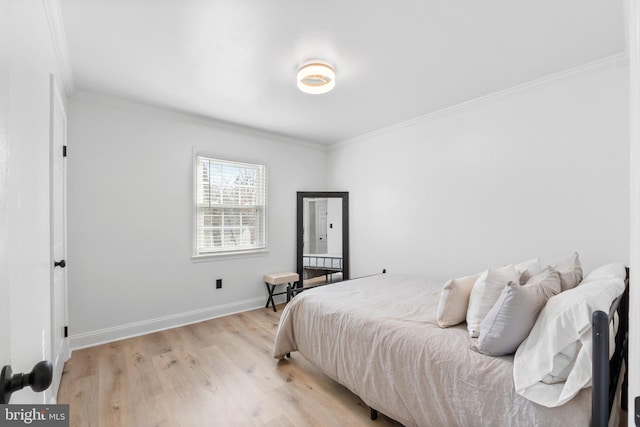 bedroom featuring baseboards, crown molding, and light wood-style floors