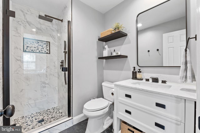 bathroom featuring vanity, toilet, baseboards, and a marble finish shower