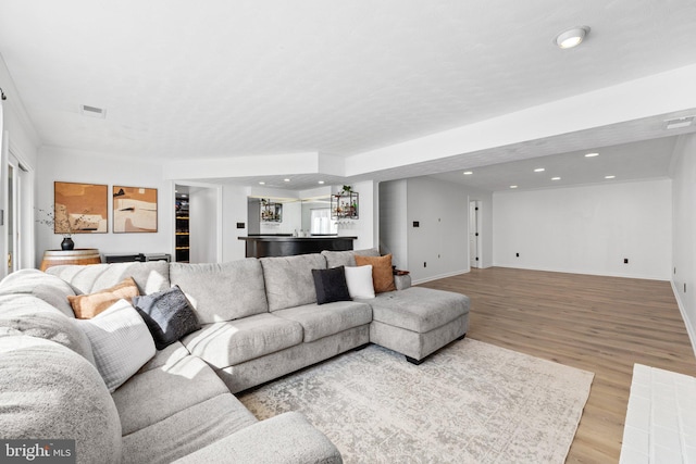 living room with recessed lighting, baseboards, and wood finished floors