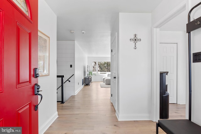 entryway with baseboards and light wood finished floors