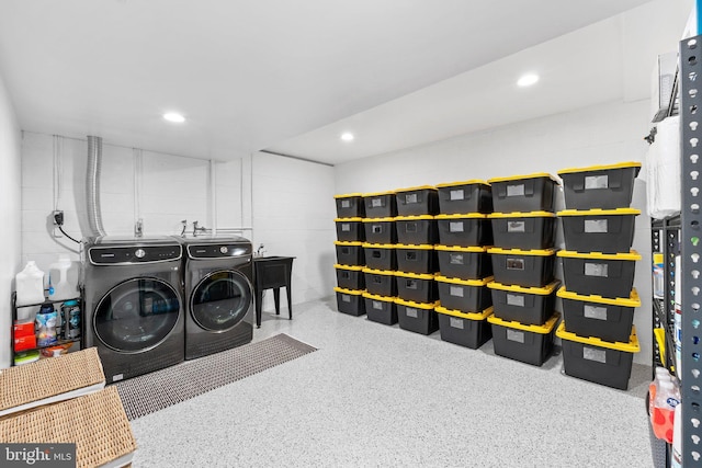 laundry area featuring washer and clothes dryer, recessed lighting, and concrete block wall