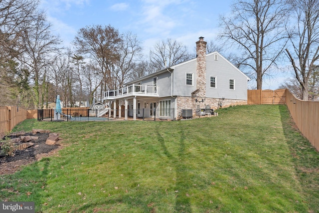 rear view of house with a playground, a lawn, a fenced backyard, and a chimney