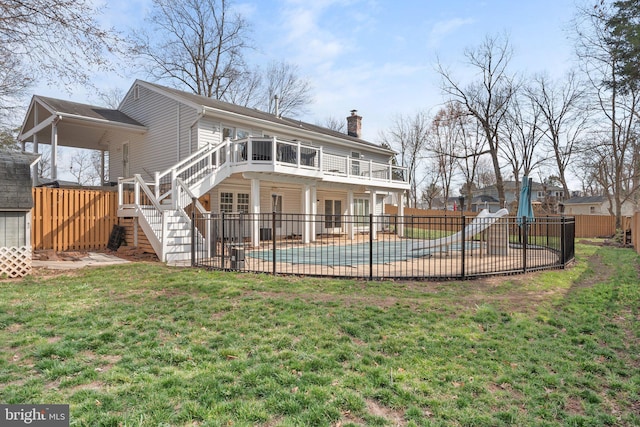 rear view of house featuring stairway, fence, a chimney, a patio area, and a lawn