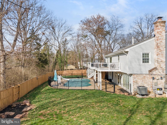 view of yard featuring cooling unit, a fenced in pool, a fenced backyard, a deck, and a patio area