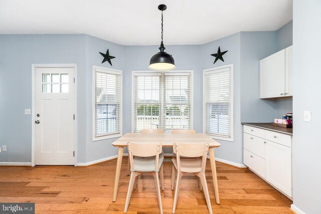 dining room featuring light wood-style flooring and baseboards