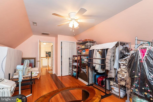 office with a ceiling fan, vaulted ceiling, wood finished floors, and visible vents