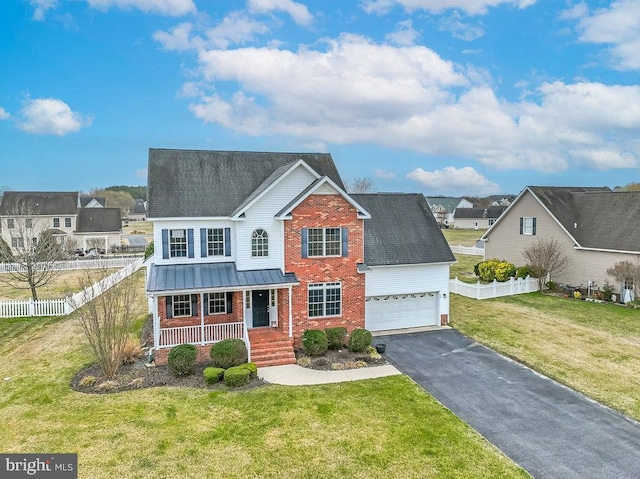 traditional-style house with brick siding, fence, aphalt driveway, a porch, and a garage