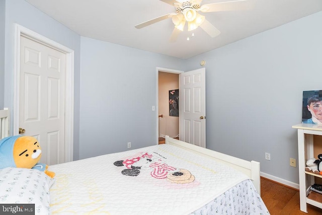 bedroom featuring wood finished floors, baseboards, and ceiling fan