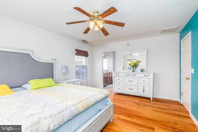 bedroom with baseboards, visible vents, light wood finished floors, ensuite bath, and ceiling fan