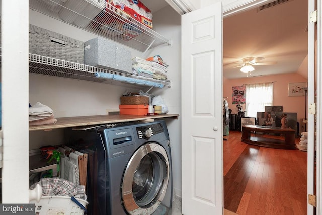 clothes washing area with visible vents, hardwood / wood-style floors, laundry area, washer / clothes dryer, and a ceiling fan