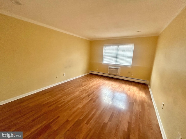 empty room featuring ornamental molding, wood finished floors, baseboards, and a baseboard radiator