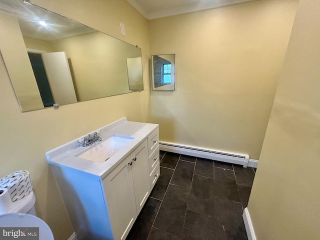 bathroom with a baseboard heating unit, toilet, vanity, and baseboards