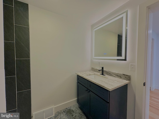 bathroom featuring visible vents, vanity, and baseboards