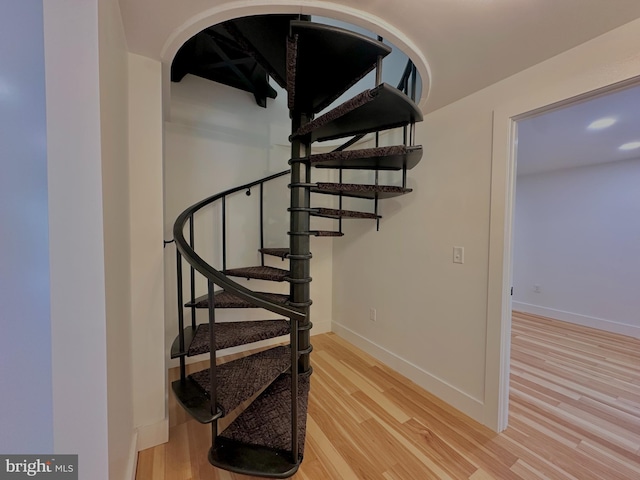 staircase with wood finished floors and baseboards